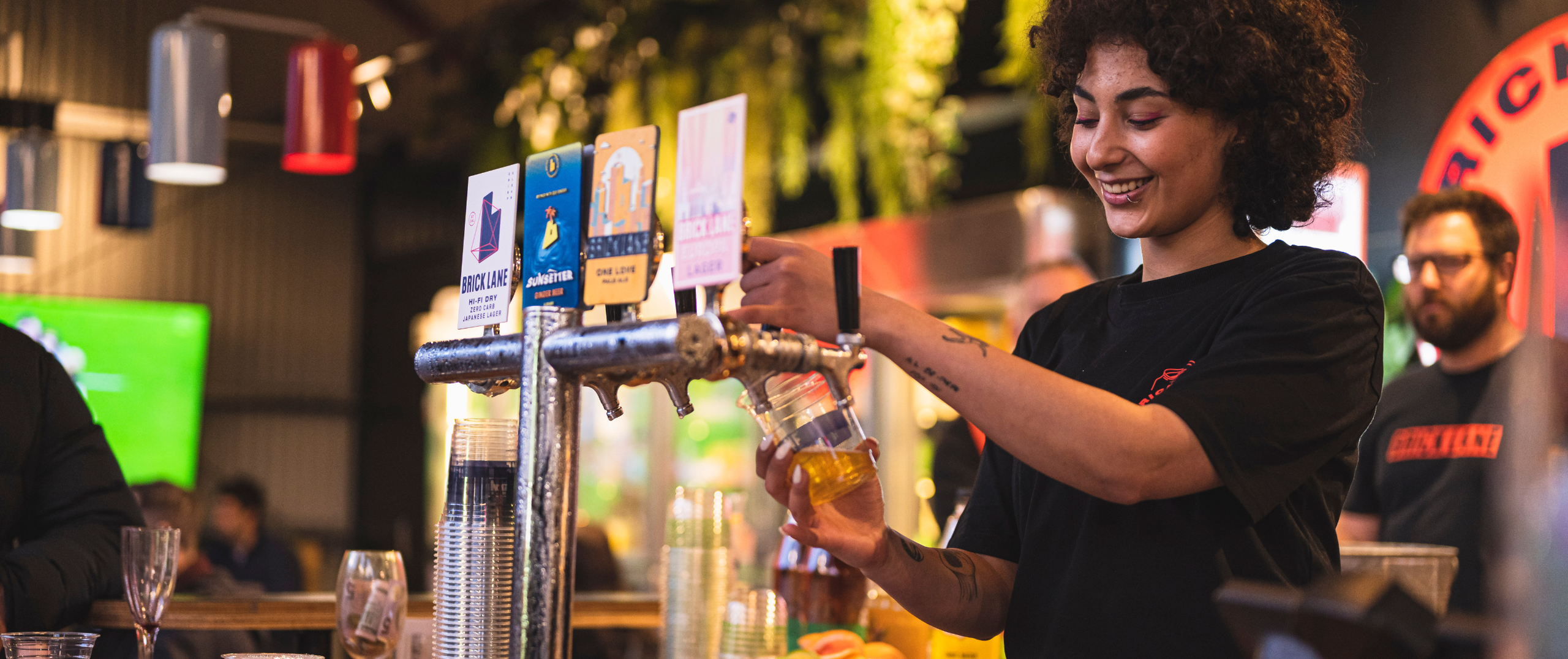 girl pouring a beer at a bar